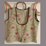 Embroidered beige blouse with pink floral designs and black piping.